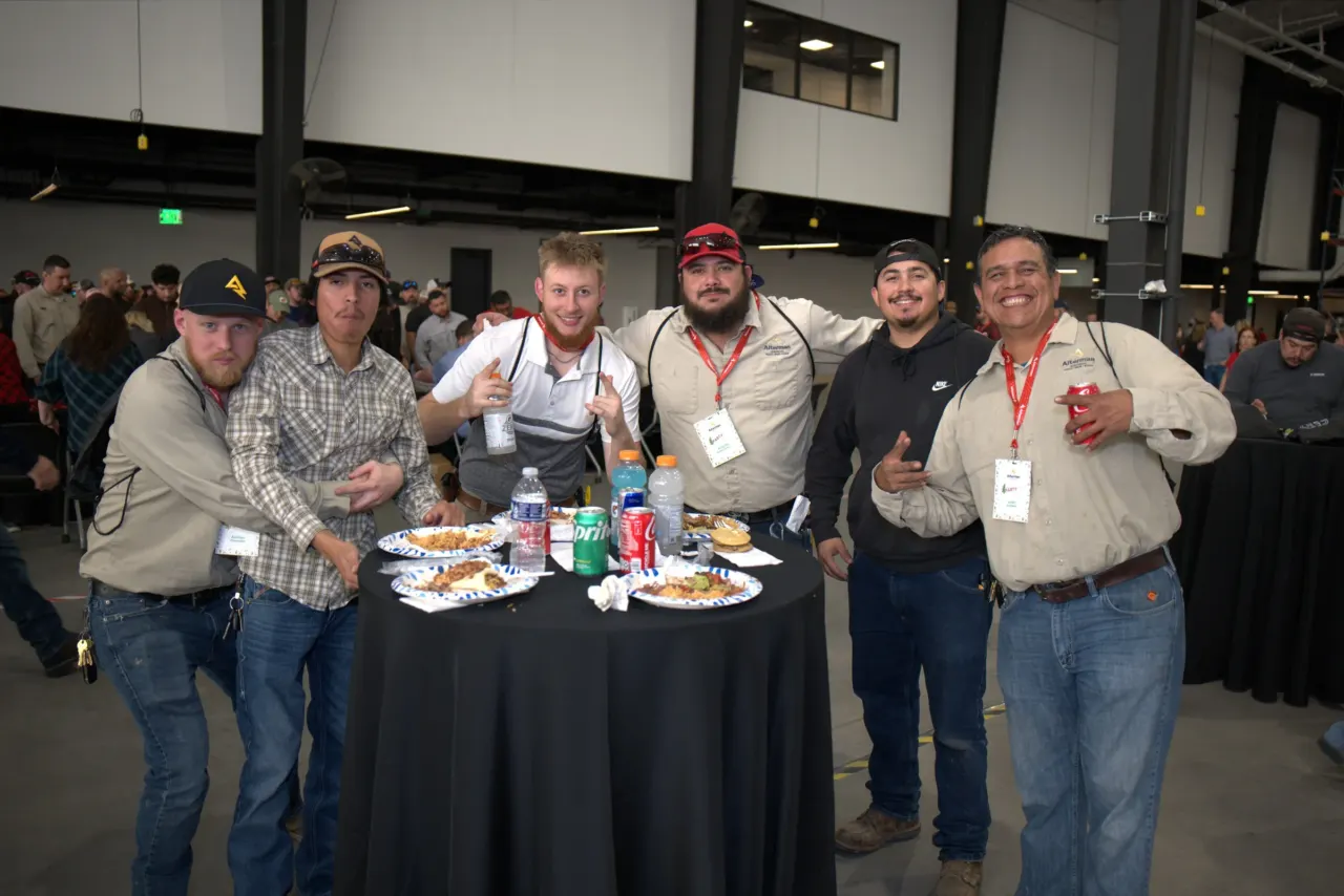 Five attendees pose together at a corporate gathering.