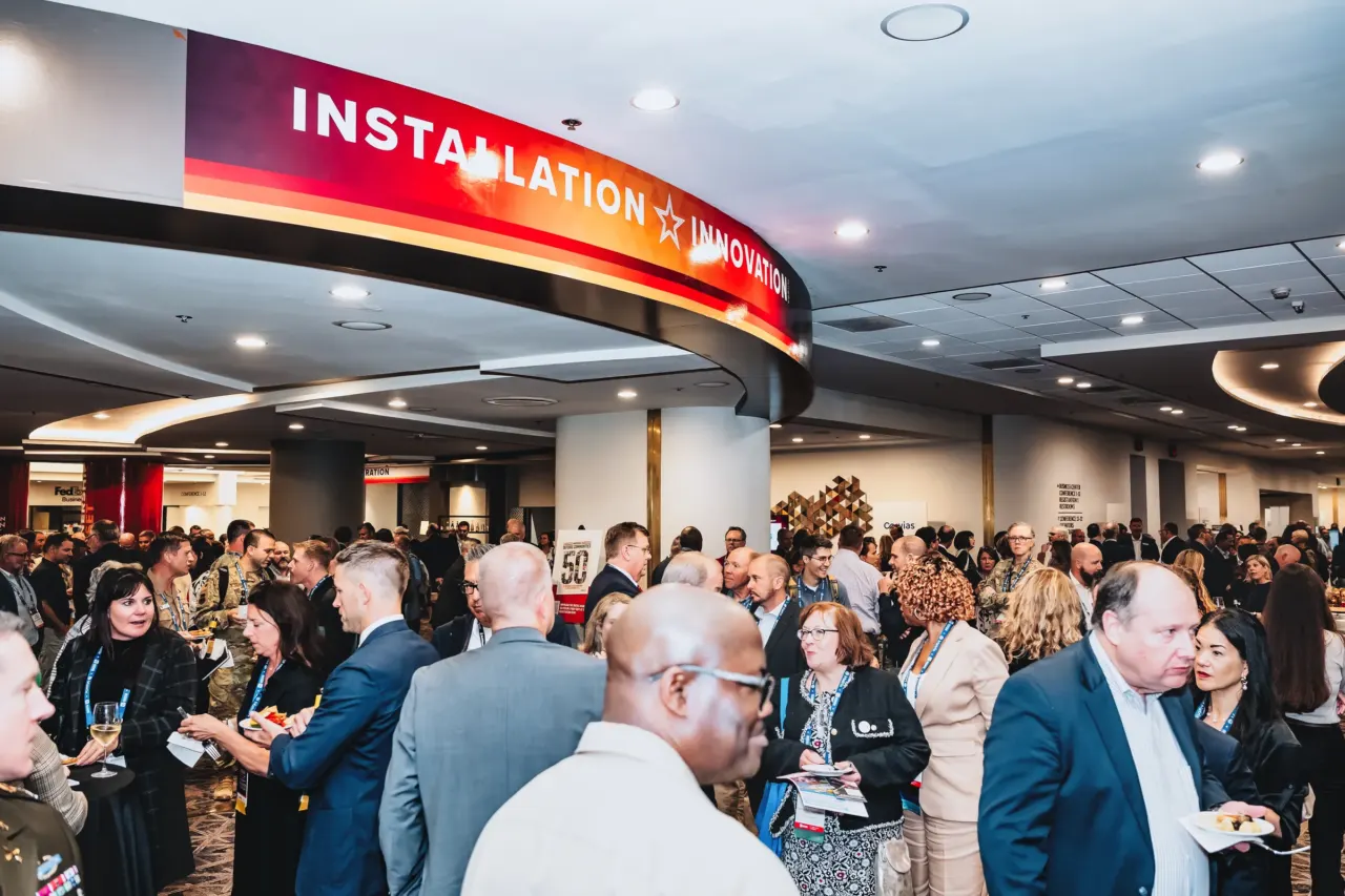 Attendees gather beneath the Installation XIX event sign.