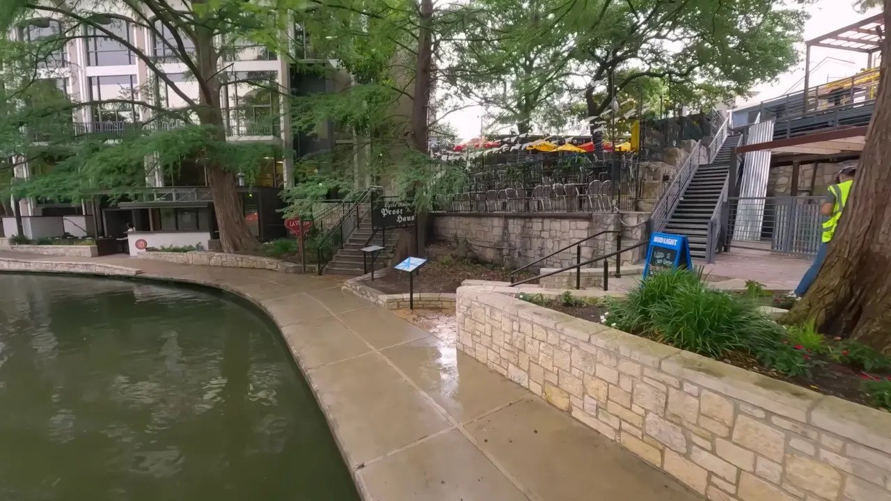 Elevated view of an outdoor restaurant patio beside a landscaped waterway.