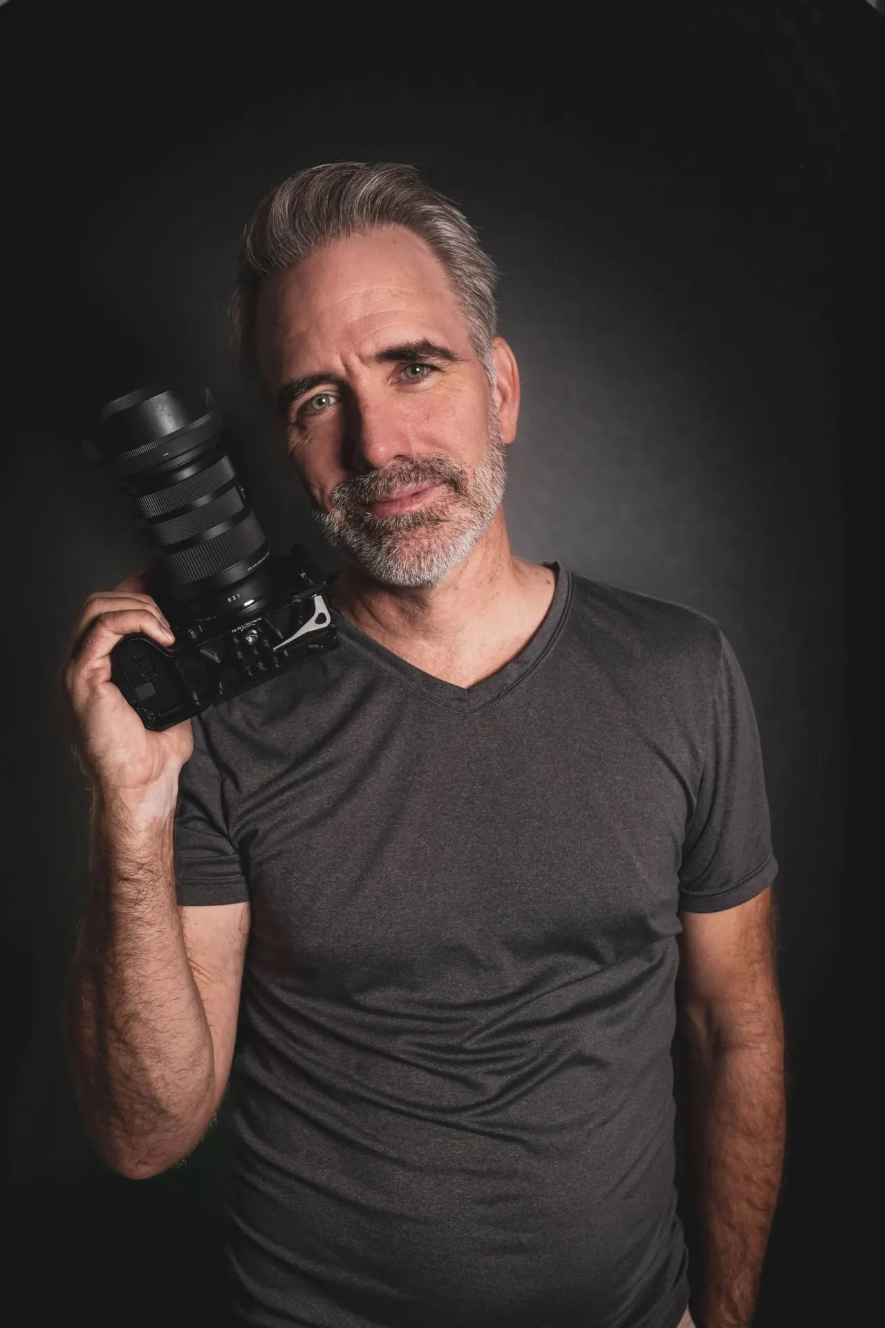 Todd Larson holds his camera for a portrait.